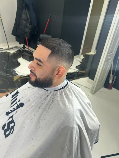 Precision skin fade with a crisp beard line, side profile