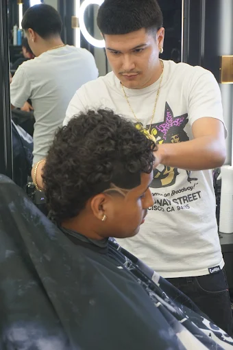 Barber detailing a textured crop fade in the chair